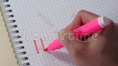 一个女人的手在记事本上用粉红色的记号笔写着“我爱你”这个词。